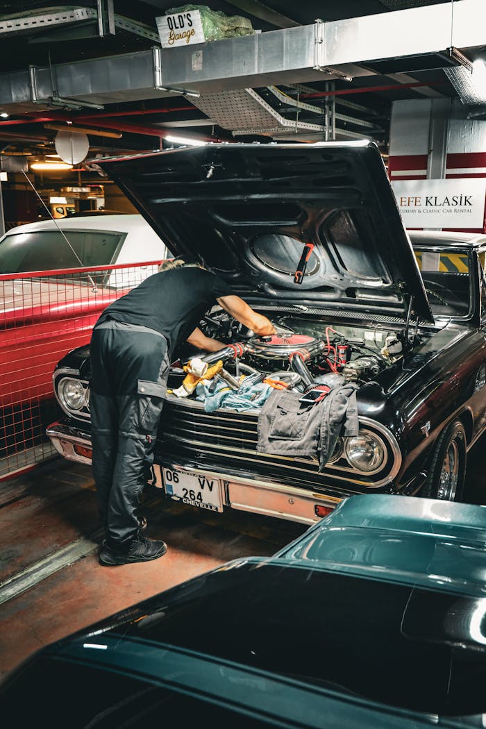 Mechanic repairing classic car engine in an Ankara garage, capturing vintage automotive repair scene.